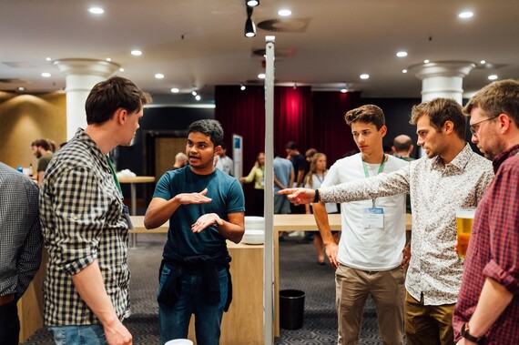 young men viewing and discussing boards with posters